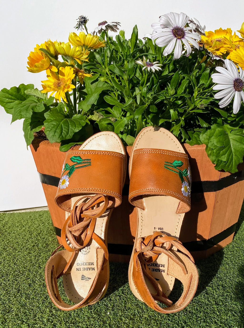 Open toe and laced huarache sandals with embroidered daisies