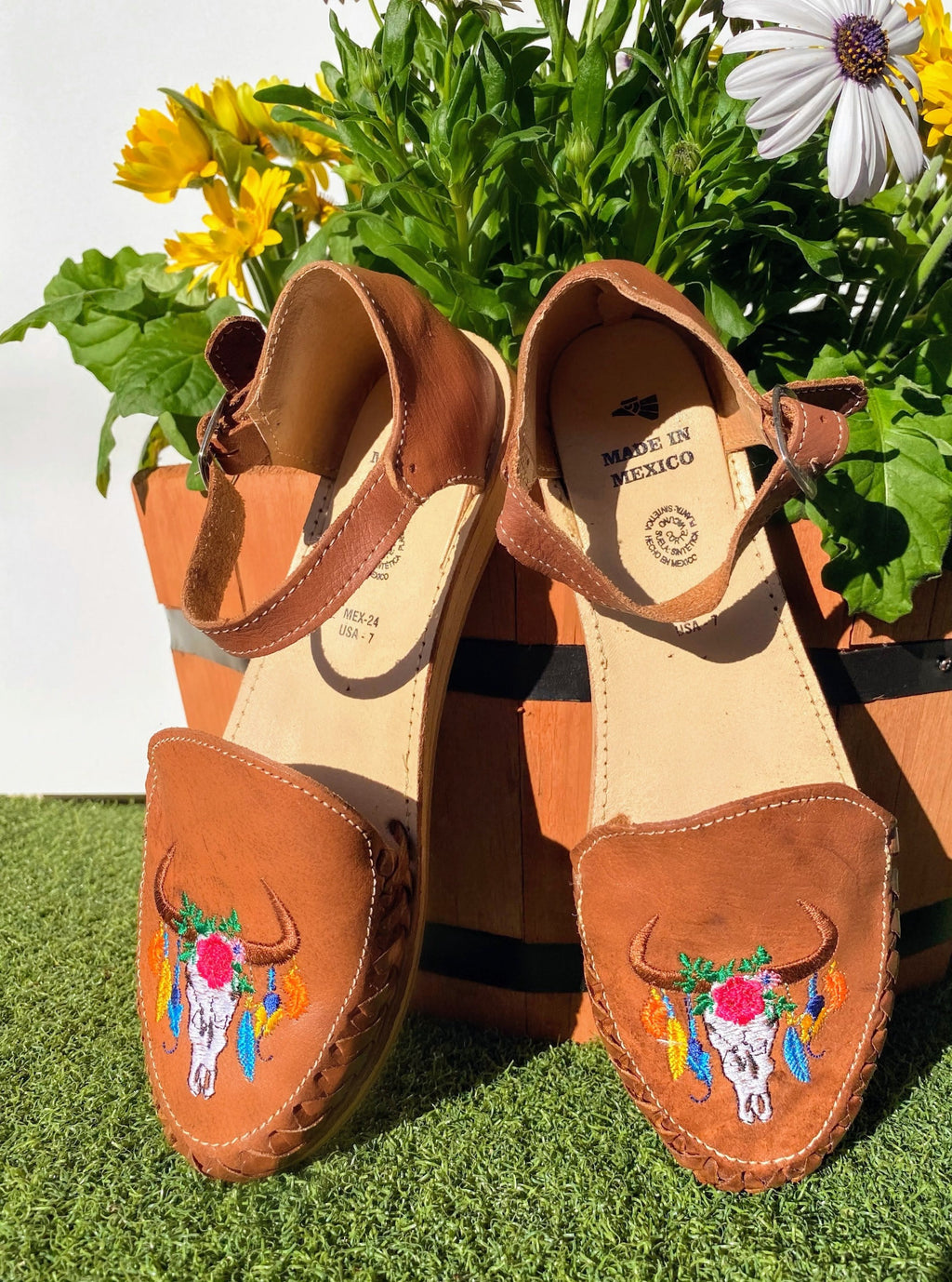 Women closed toe huarache sandals with buckle strap and embroidered bull design.